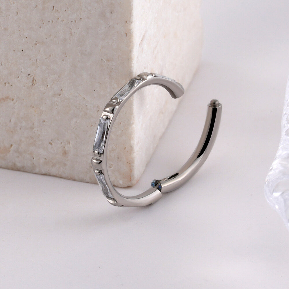 Manek° Piercing de hélice y conch, rectangular, de titanio, grado ASTM F136, con engaste de garras y bisagra, calibre 16G.