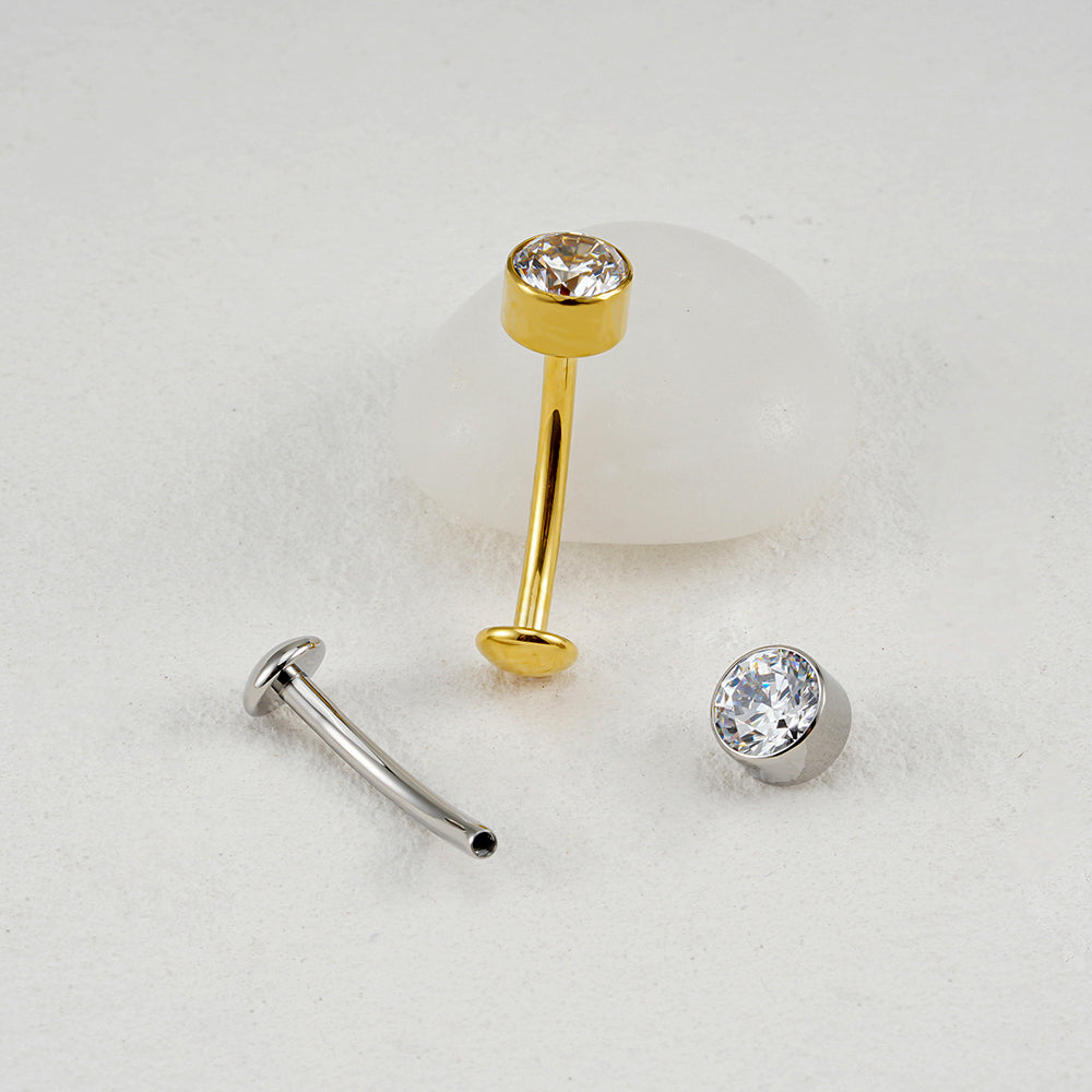 Manek° Piercing para ombligo  ASTM F136 de titanio, calibre 14G, con base convexa y circonitas cúbicas. Disponible en barras curvas de 10 mm.