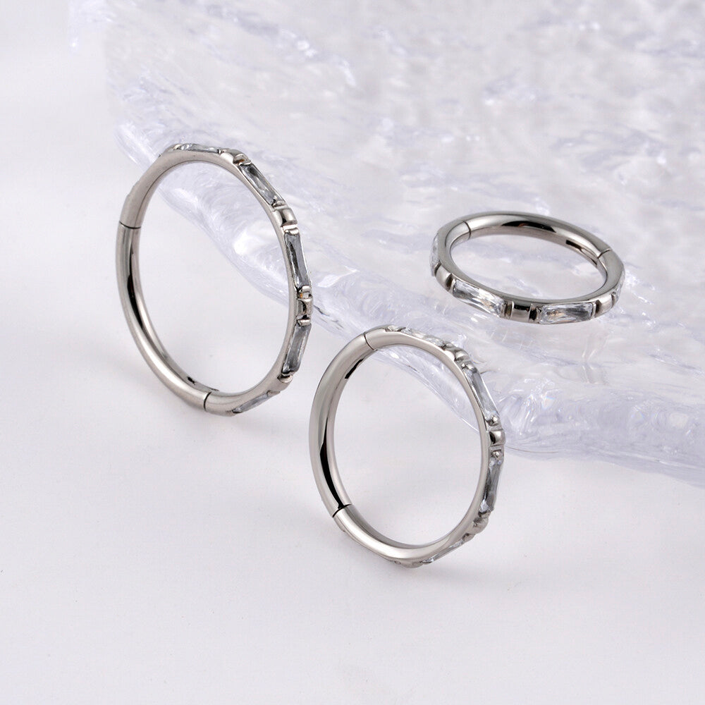 Manek° Piercing de hélice y conch, rectangular, de titanio, grado ASTM F136, con engaste de garras y bisagra, calibre 16G.